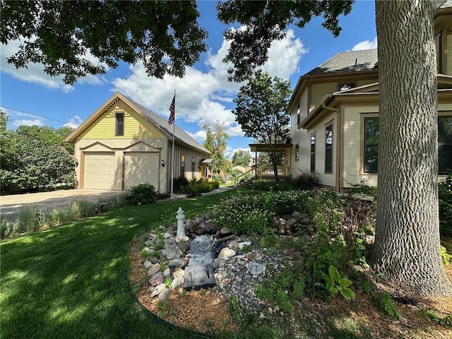 view of home's exterior with a lawn, an outdoor structure, and a garage