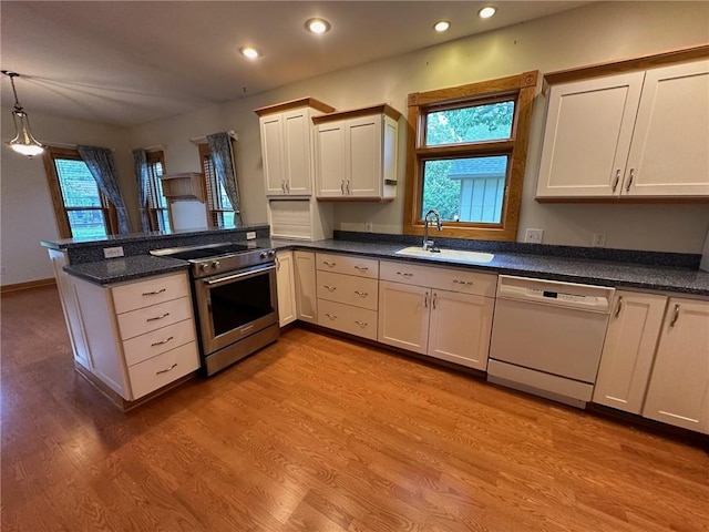 kitchen with pendant lighting, kitchen peninsula, electric range, sink, and white dishwasher