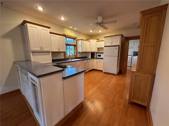 kitchen featuring white cabinets, kitchen peninsula, sink, and white appliances