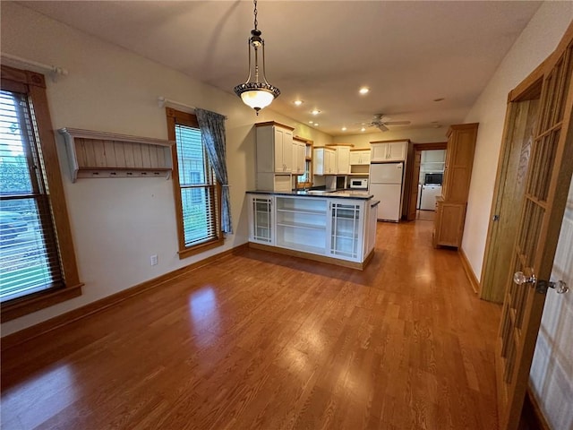 kitchen featuring ceiling fan, white appliances, light wood-type flooring, and hanging light fixtures