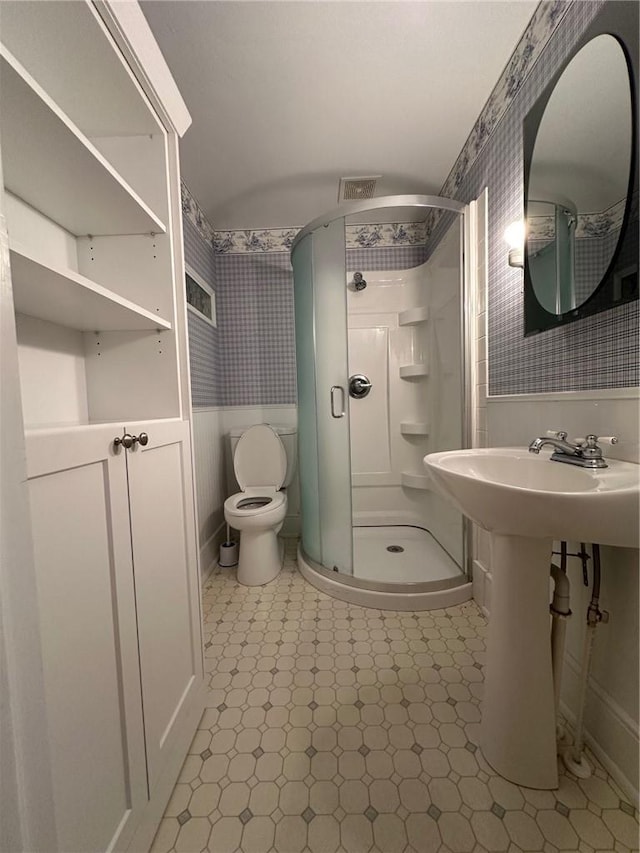 bathroom featuring sink, toilet, and an enclosed shower