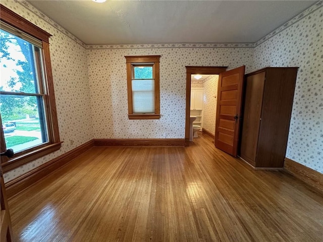 spare room with wood-type flooring and a healthy amount of sunlight