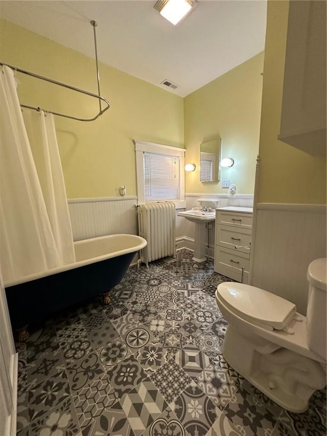 bathroom featuring tile patterned floors, toilet, radiator, and shower / bath combo