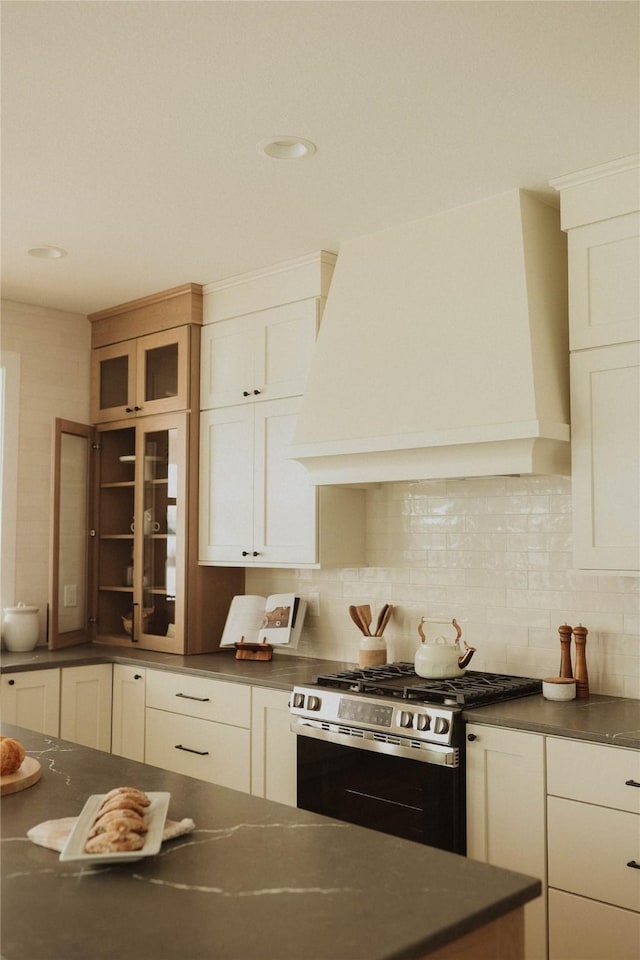 kitchen featuring decorative backsplash, gas stove, and premium range hood