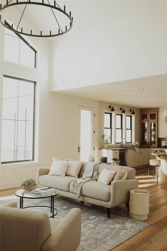 living room featuring hardwood / wood-style floors, a towering ceiling, and sink