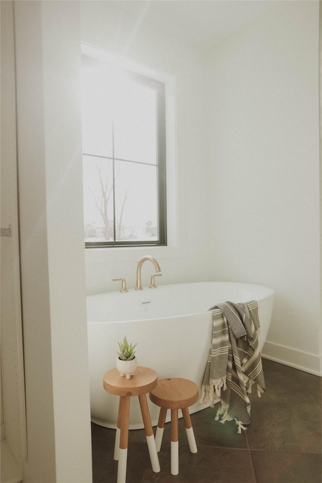 bathroom with tile patterned floors and a bath