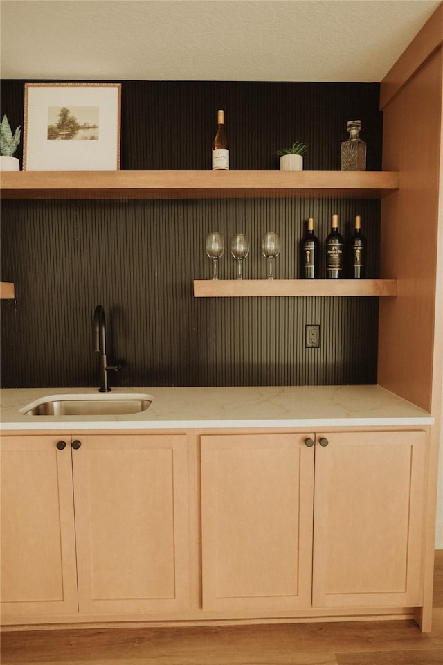 bar featuring sink and light wood-type flooring