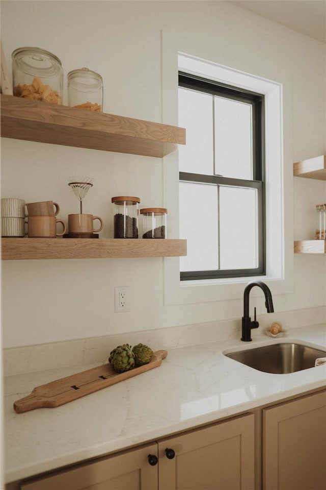 kitchen featuring light stone countertops and sink