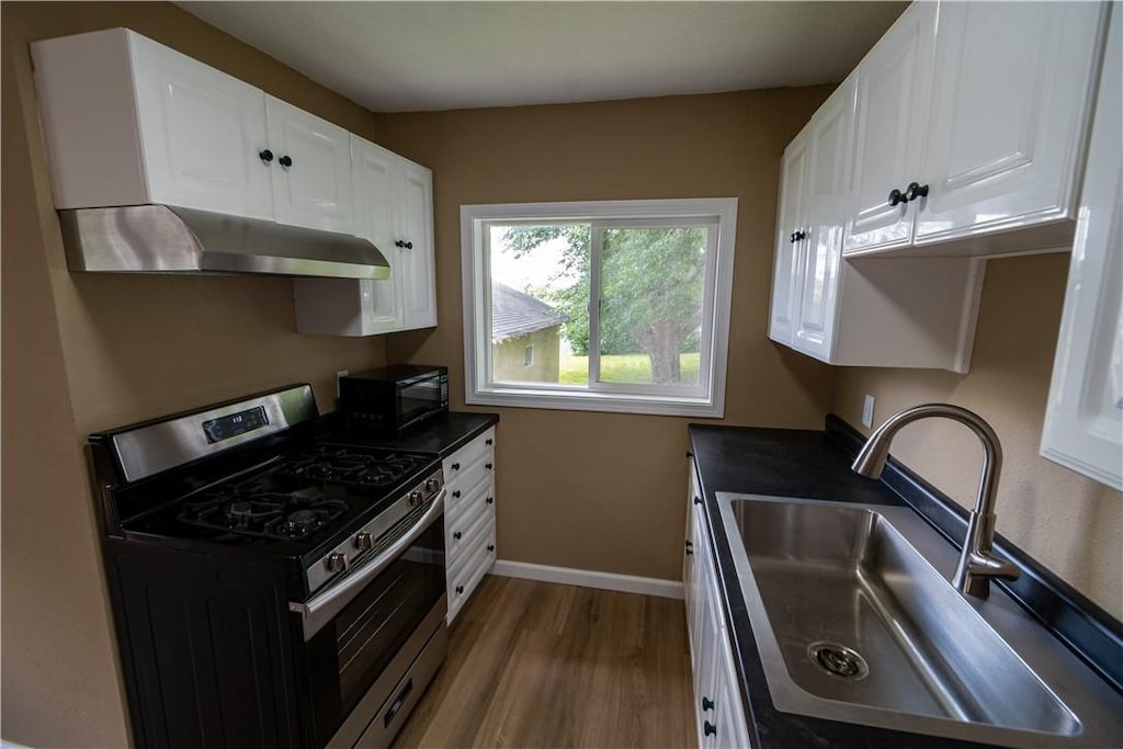 621 Water St, Kellogg, IA 50135 - kitchen with gas range, sink, and white cabinets