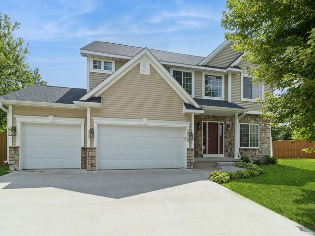 craftsman house with a front yard and a garage