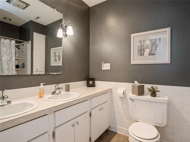 bathroom featuring toilet, tile walls, tile patterned floors, vanity, and curtained shower