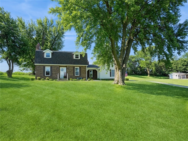 cape cod house featuring a front yard