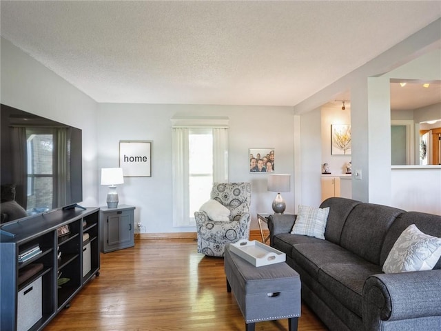 living room featuring a textured ceiling and hardwood / wood-style flooring