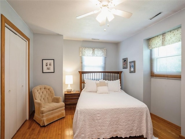 bedroom featuring ceiling fan, a closet, and light hardwood / wood-style flooring