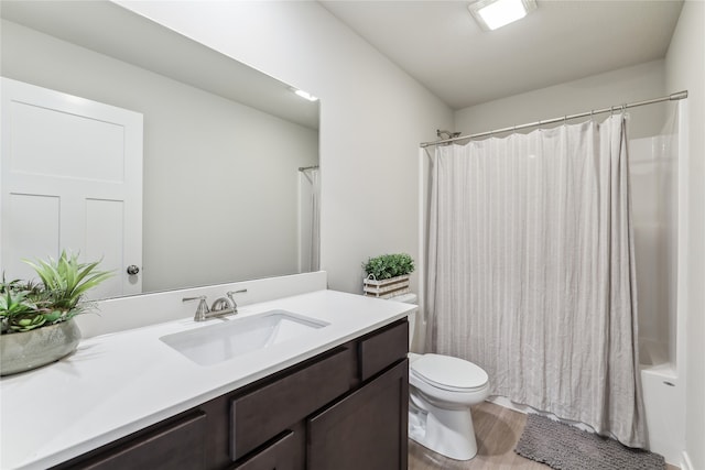 full bathroom featuring hardwood / wood-style flooring, vanity, toilet, and shower / tub combo