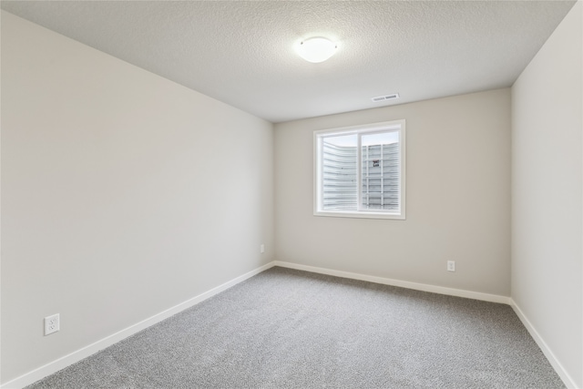 carpeted spare room featuring a textured ceiling