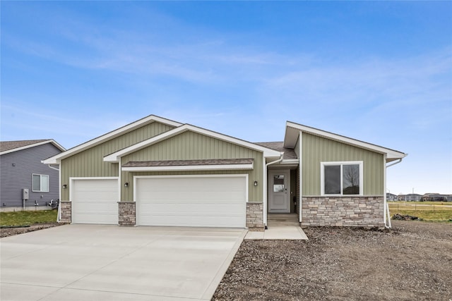 2925 3rd Ave SW, Altoona, IA 50009 - view of front of home featuring an attached garage, stone siding, concrete driveway, board and batten siding, and a shingled roof