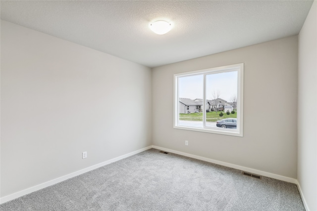 carpeted spare room featuring a textured ceiling