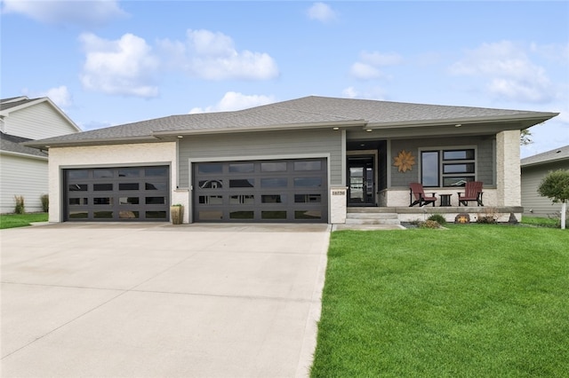 prairie-style home with a garage, a porch, and a front yard