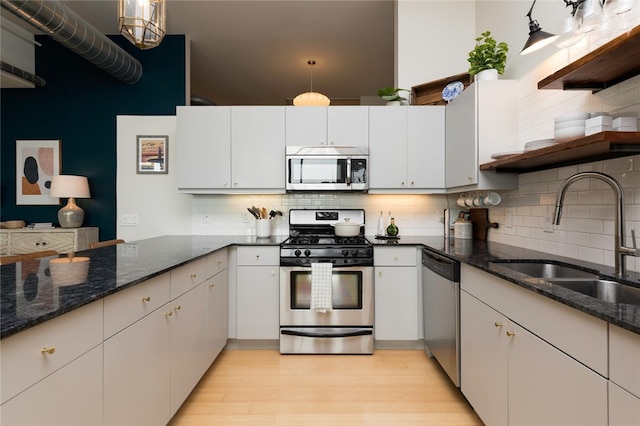 kitchen with tasteful backsplash, sink, appliances with stainless steel finishes, and light wood-type flooring