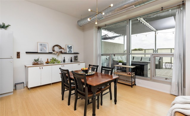 dining room with a chandelier and light wood-type flooring