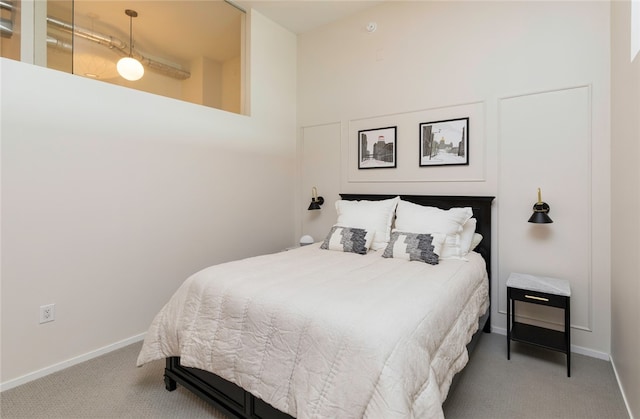 carpeted bedroom with a towering ceiling