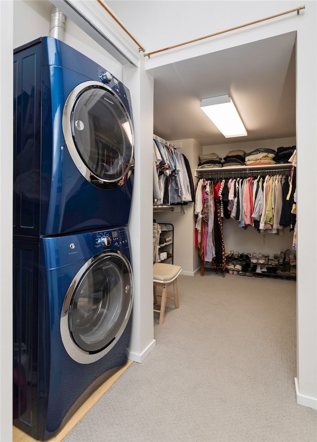 clothes washing area featuring stacked washer and clothes dryer and carpet