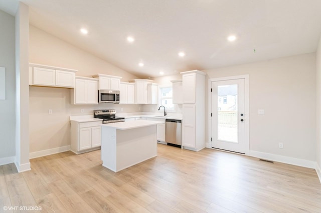 kitchen with light wood-style flooring, visible vents, stainless steel appliances, and a center island