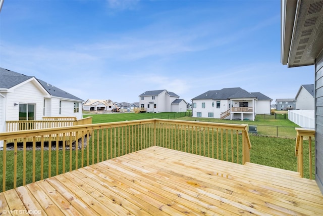 wooden deck with a residential view, a fenced backyard, and a yard