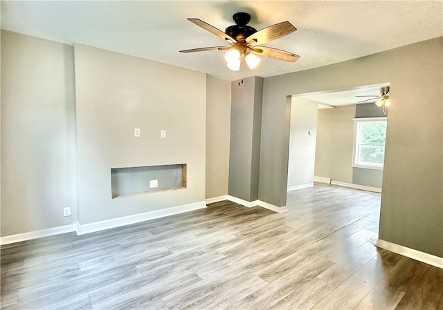 unfurnished living room featuring a textured ceiling, ceiling fan, and hardwood / wood-style floors