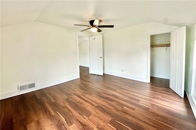 unfurnished bedroom featuring ceiling fan, lofted ceiling, a closet, and wood-type flooring