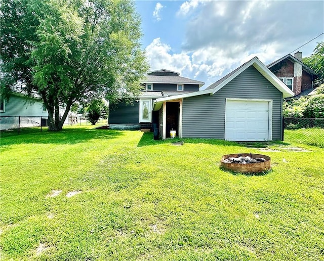 exterior space with a garage, a fire pit, and a front yard