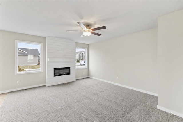 303 29th St SW, Altoona, IA 50009 - unfurnished living room with healthy amount of natural light, ceiling fan, and carpet flooring