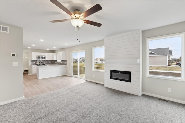 303 29th St SW, Altoona, IA 50009 - unfurnished living room featuring ceiling fan, light colored carpet, a fireplace, and recessed lighting