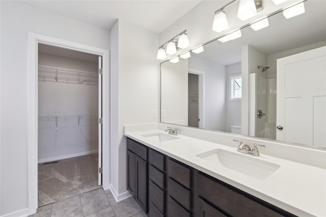 bathroom featuring tile patterned floors, vanity, toilet, and a shower