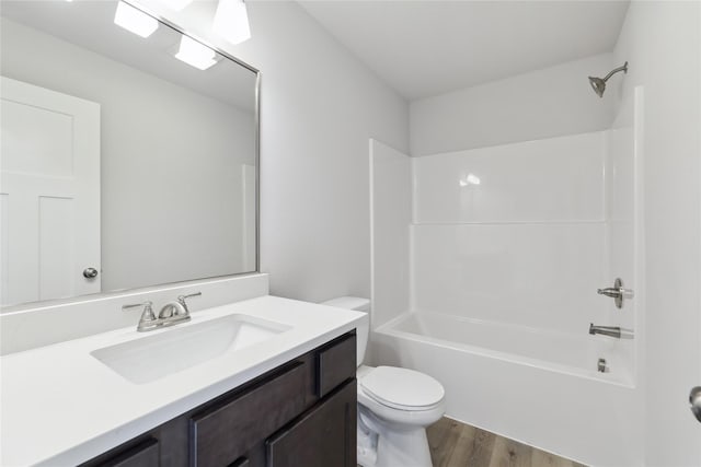 full bathroom with hardwood / wood-style flooring, vanity, shower / bathtub combination, and toilet