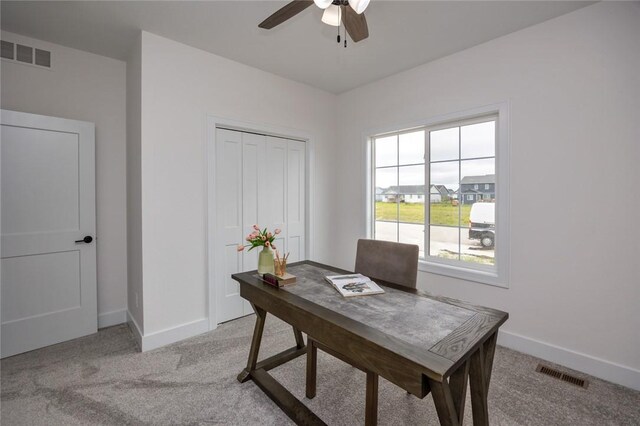 office space with light carpet and ceiling fan