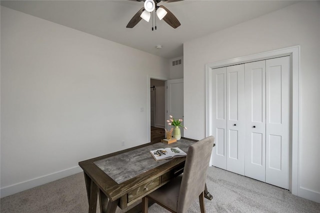 carpeted home office featuring ceiling fan