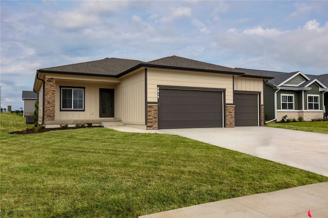 view of front of home featuring a garage, central AC unit, and a front yard