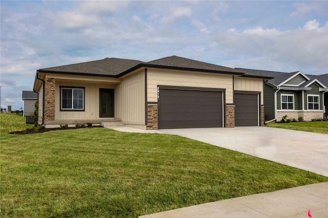 view of front facade featuring a garage, central AC, and a front yard