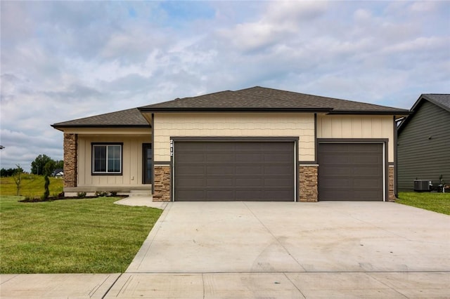 view of front of property with a garage, central AC unit, and a front lawn