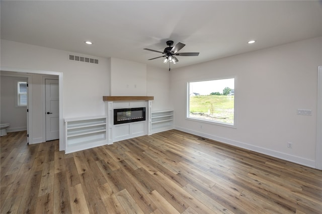 unfurnished living room featuring ceiling fan and hardwood / wood-style floors