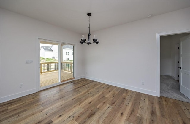 unfurnished dining area featuring a notable chandelier and light hardwood / wood-style flooring