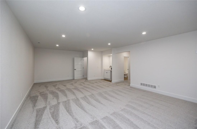 unfurnished bedroom featuring light carpet and connected bathroom