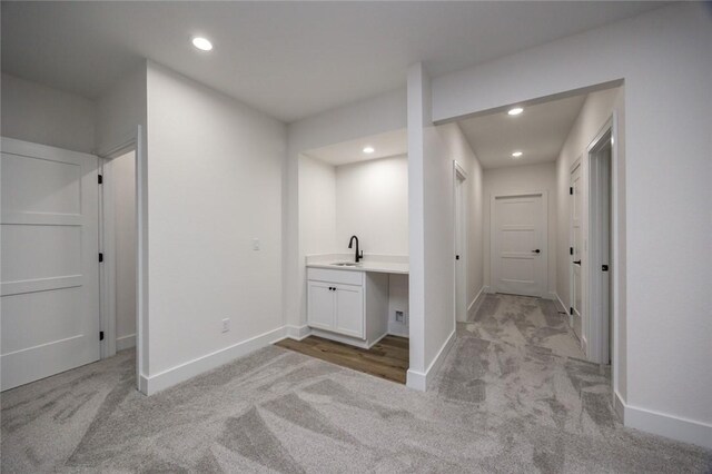 corridor with sink and light carpet