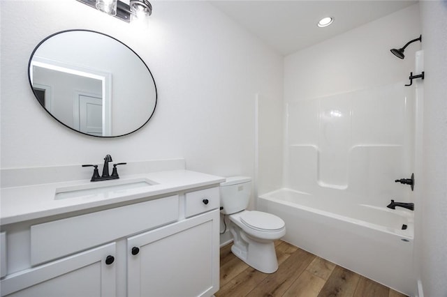 full bathroom with shower / washtub combination, toilet, vanity, and wood-type flooring