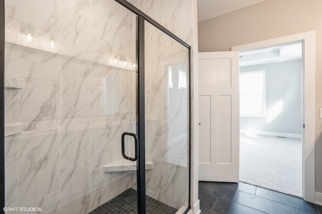 bathroom with a shower with door, a textured ceiling, and tile patterned floors