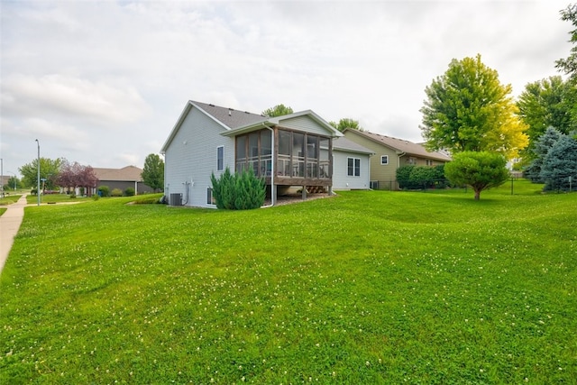 rear view of property with a yard, a sunroom, and cooling unit