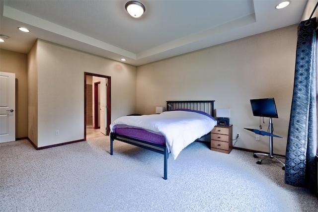 bedroom featuring carpet and a tray ceiling