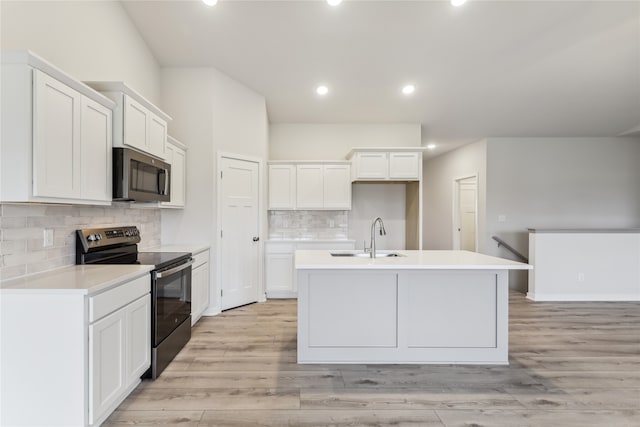 kitchen with light hardwood / wood-style floors, white cabinetry, and black range with electric cooktop